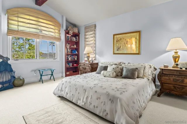 a bedroom with a bed and a dresser next to a window