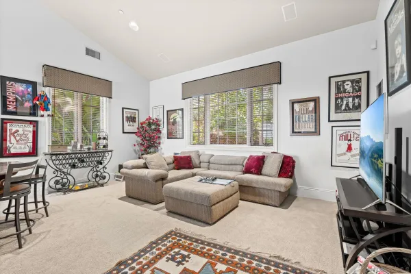 a living room with furniture a flat screen tv and a large window