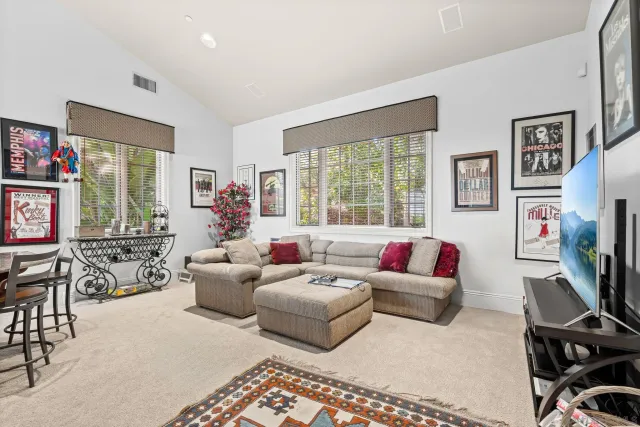 a living room with furniture a flat screen tv and a large window