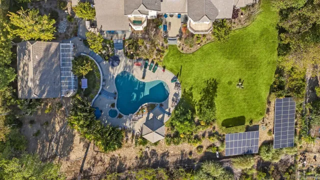 an aerial view of a residential apartment building with swimming pool and lawn chairs
