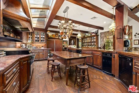 a open kitchen with a sink a counter space stainless steel appliances and cabinets