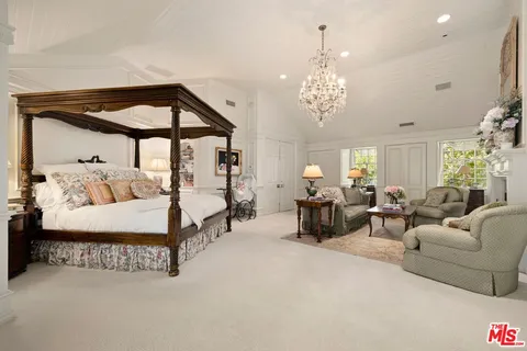 a spacious bedroom with bed and a chandelier