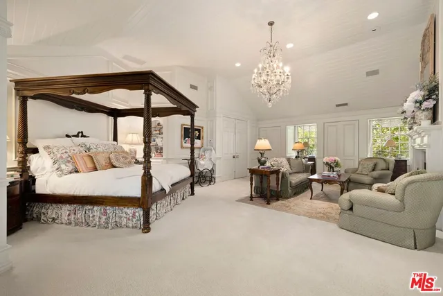 a spacious bedroom with bed and a chandelier
