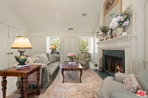 a living room with furniture a chandelier and a fireplace