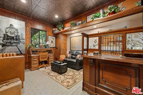 a living room with furniture a flat screen tv and floor to ceiling window