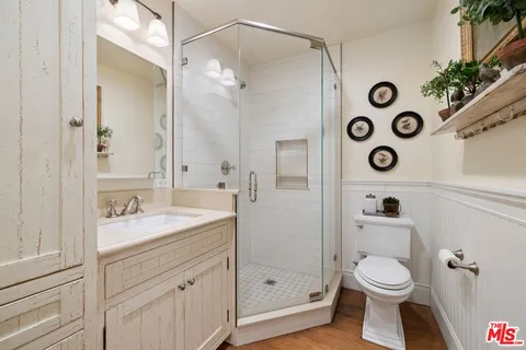 a bathroom with a granite countertop sink mirror vanity and toilet