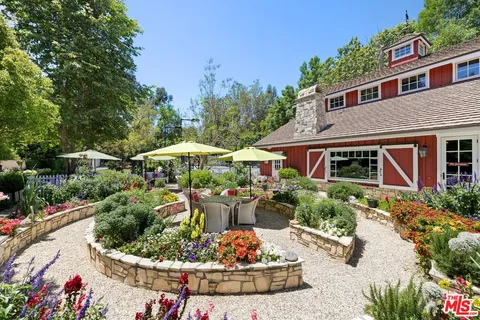 a front view of a house with a yard and potted plants