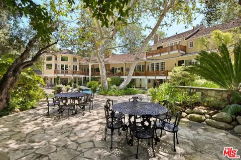 a view of a house with backyard and sitting area