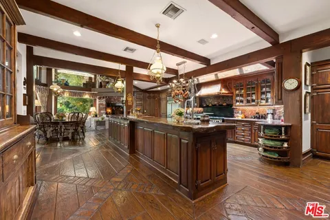a kitchen with stainless steel appliances granite countertop a table chairs and wooden floors