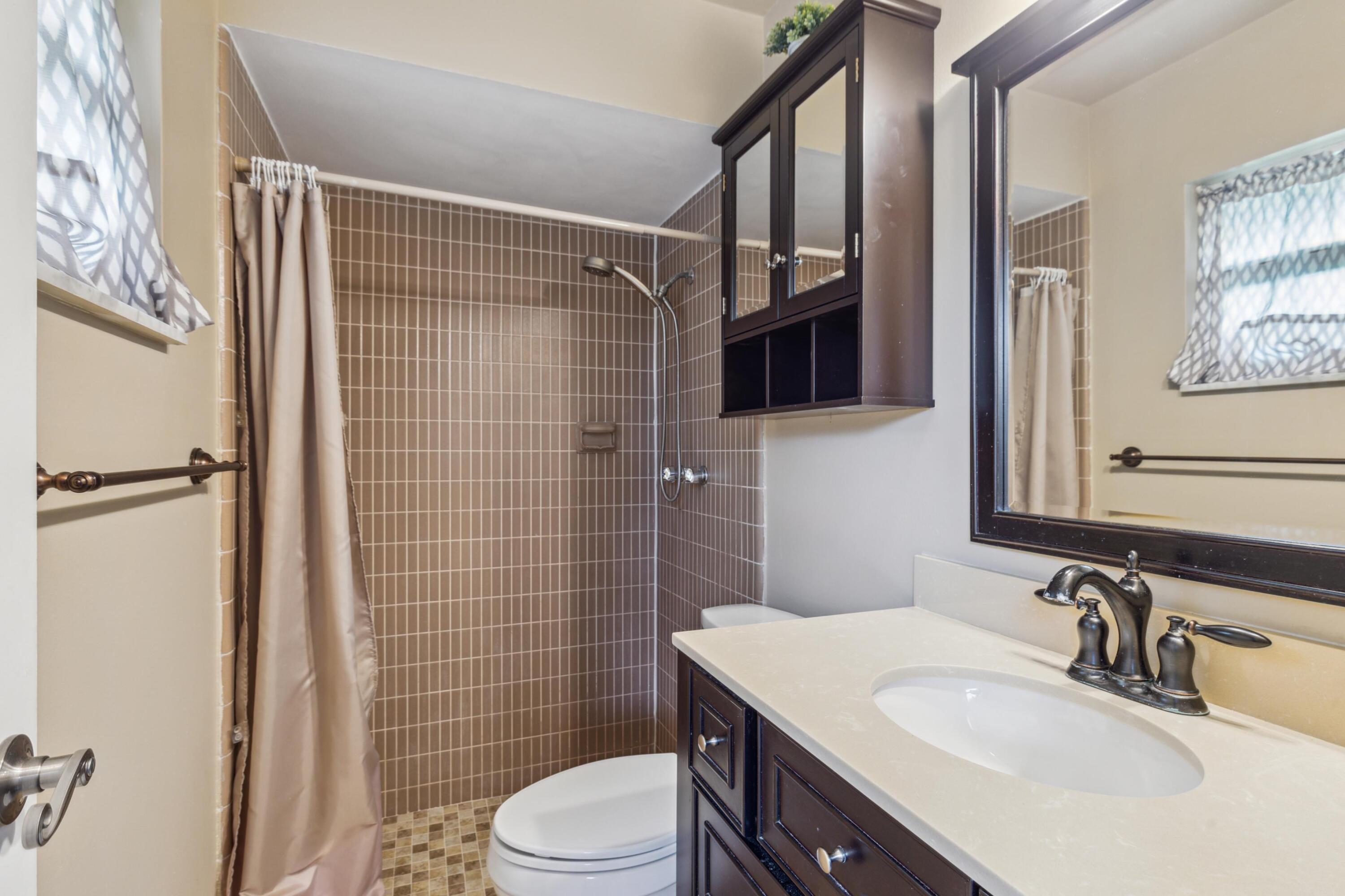 1536 Southeast Sunshine Avenue Port St. Lucie, FL 34952 - Photo 12 of 18 a bathroom with a sink toilet vanity and shower