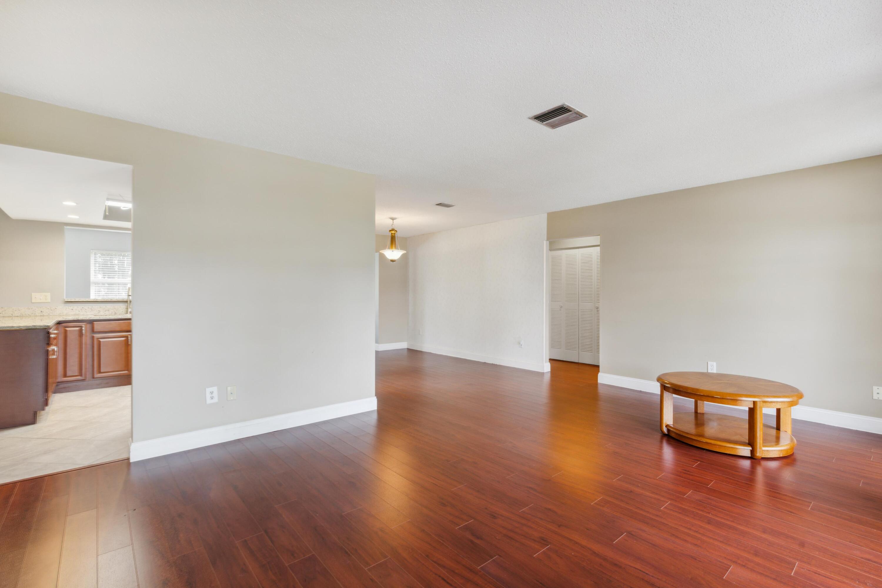 1536 Southeast Sunshine Avenue Port St. Lucie, FL 34952 - Photo 7 of 18 a view of an empty room with wooden floor