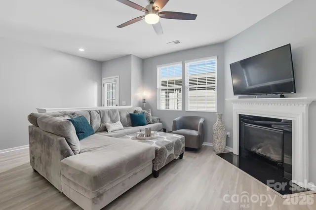 a living room with furniture a fireplace and a flat screen tv