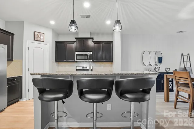 a kitchen with granite countertop a sink stainless steel appliances and cabinets