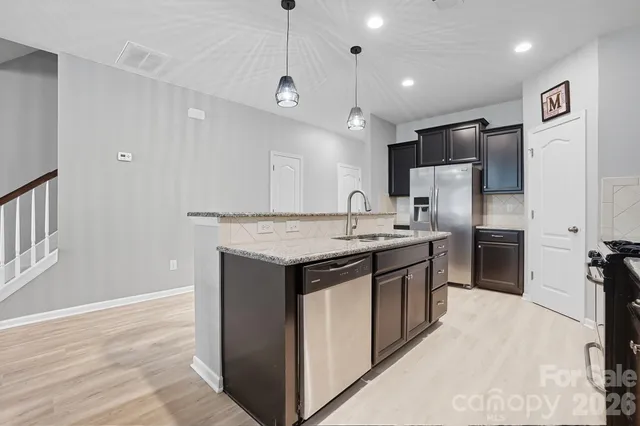 a kitchen with a sink a counter space dining table and chairs