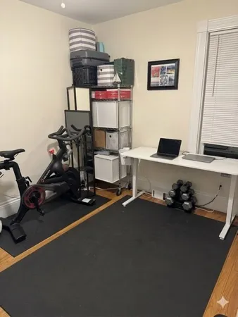 a room with gym equipment and a view of living room