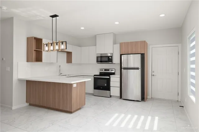 a kitchen with stainless steel appliances granite countertop a refrigerator a sink and a stove