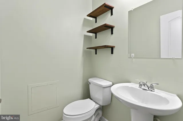 a white toilet sitting next to a bathroom sink