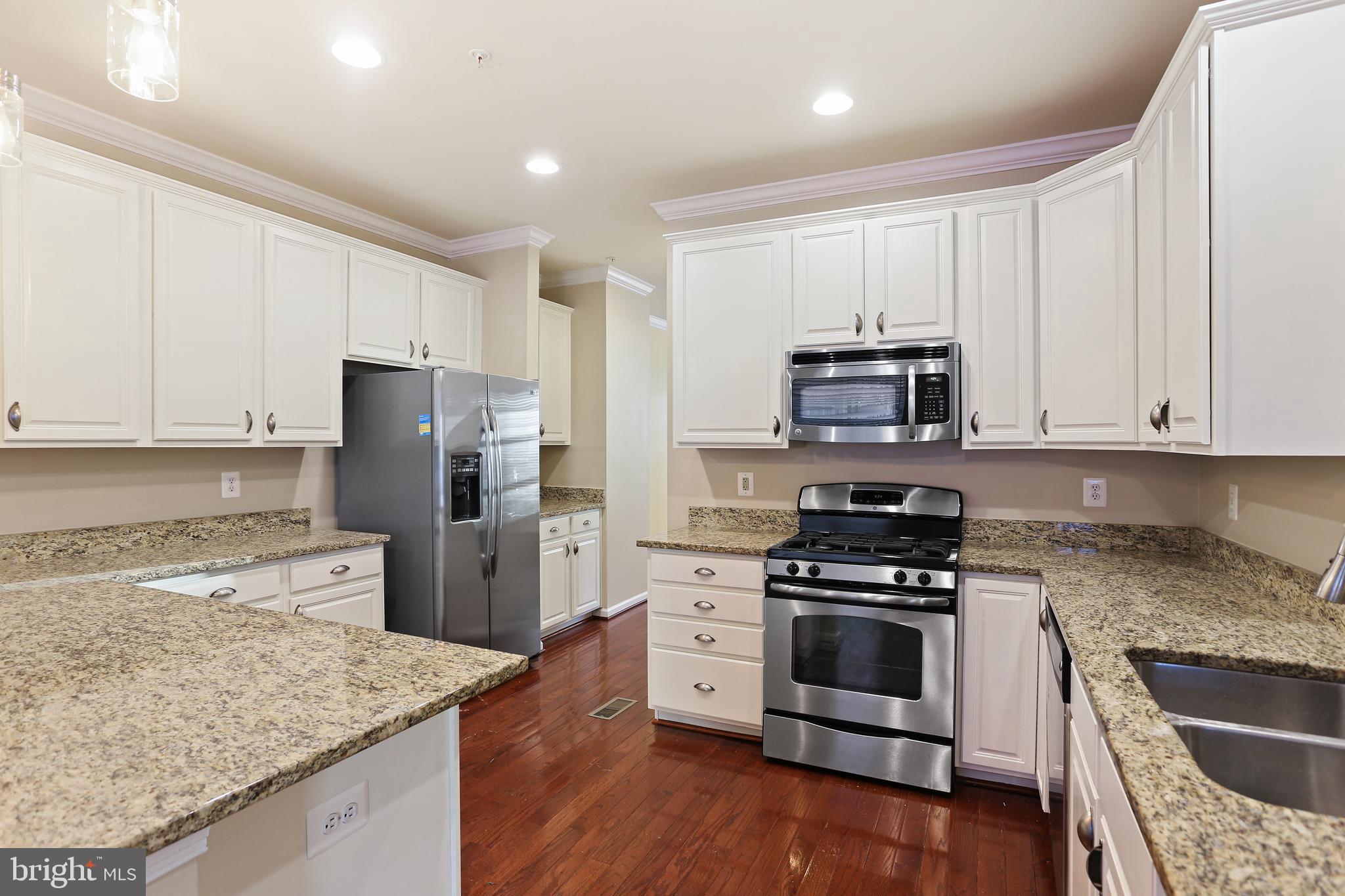 2719 Amber Crest Road Hanover, MD 21076 - Photo 3 of 22 a kitchen with granite countertop white cabinets and stainless steel appliances