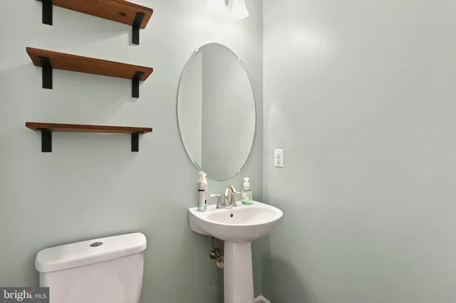 a bathroom with a toilet sink and mirror
