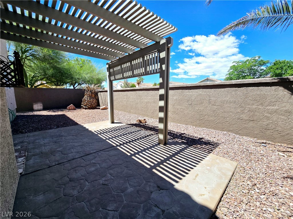 3759 Funston Way Las Vegas, NV 89129 - Photo 18 of 31 A spacious backyard patio features a pergola, offering shade and comfort for outdoor enjoyment.
