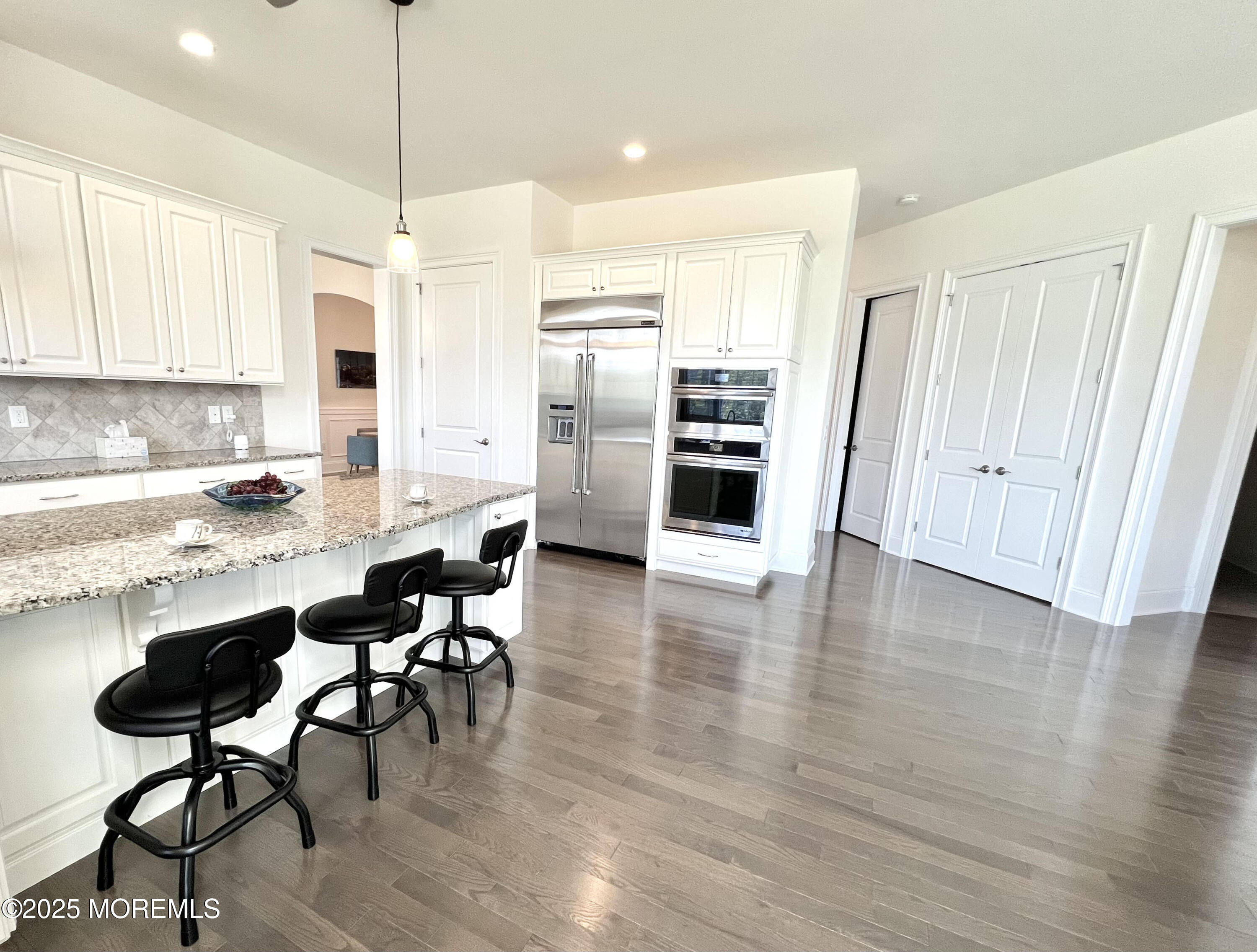 16 Exeter Way Holmdel, NJ 07733 - Photo 11 of 57 a kitchen with stainless steel appliances kitchen island granite countertop a table chairs and a refrigerator