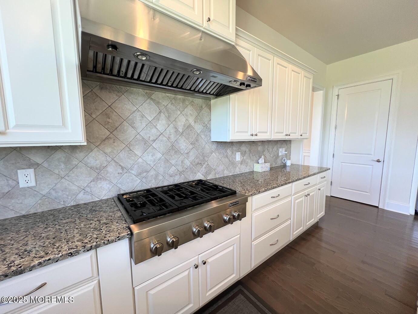 16 Exeter Way Holmdel, NJ 07733 - Photo 12 of 57 a kitchen with granite countertop a stove a sink and white cabinets