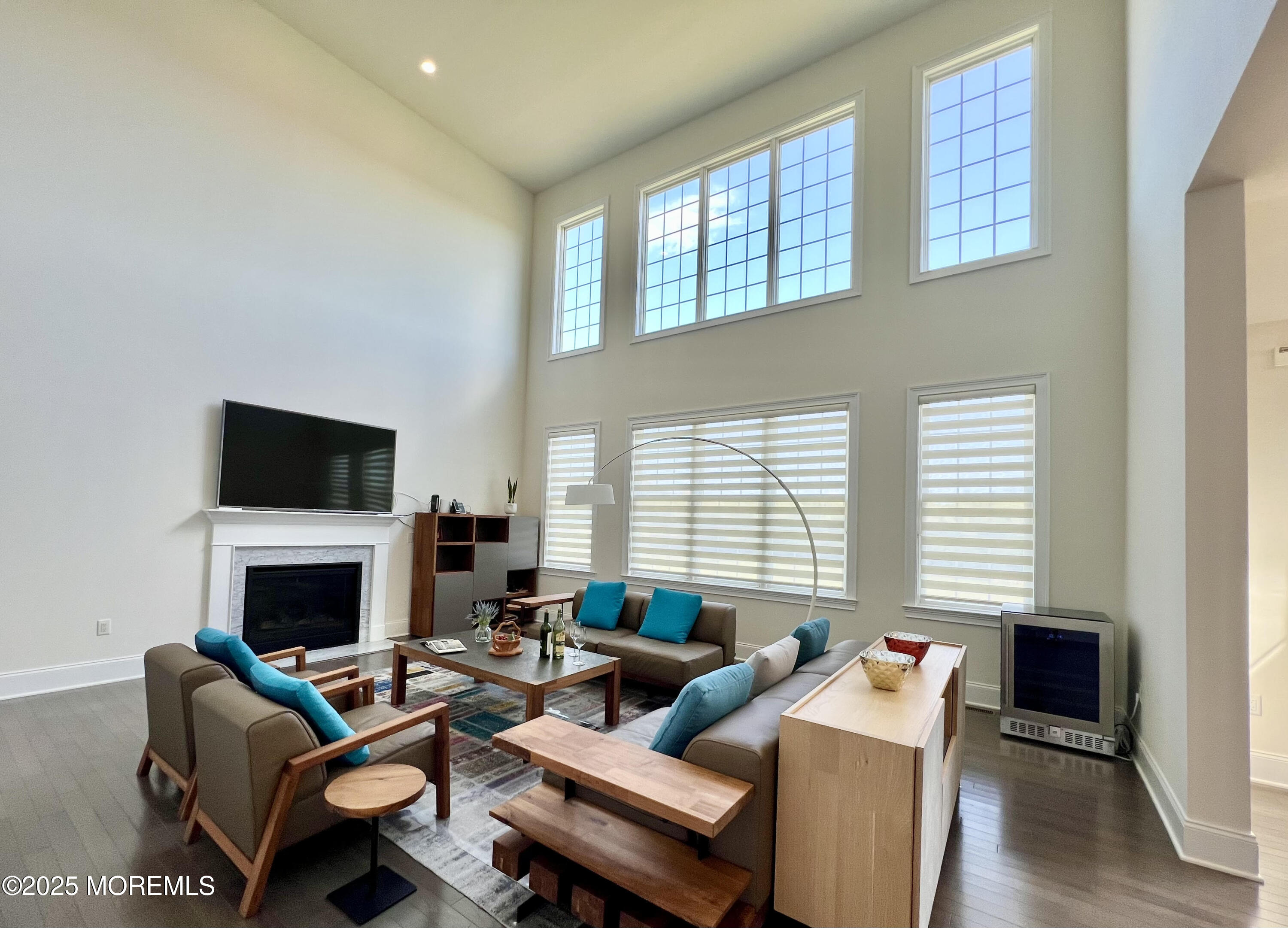 16 Exeter Way Holmdel, NJ 07733 - Photo 2 of 57 a living room with furniture a flat screen tv and a fireplace