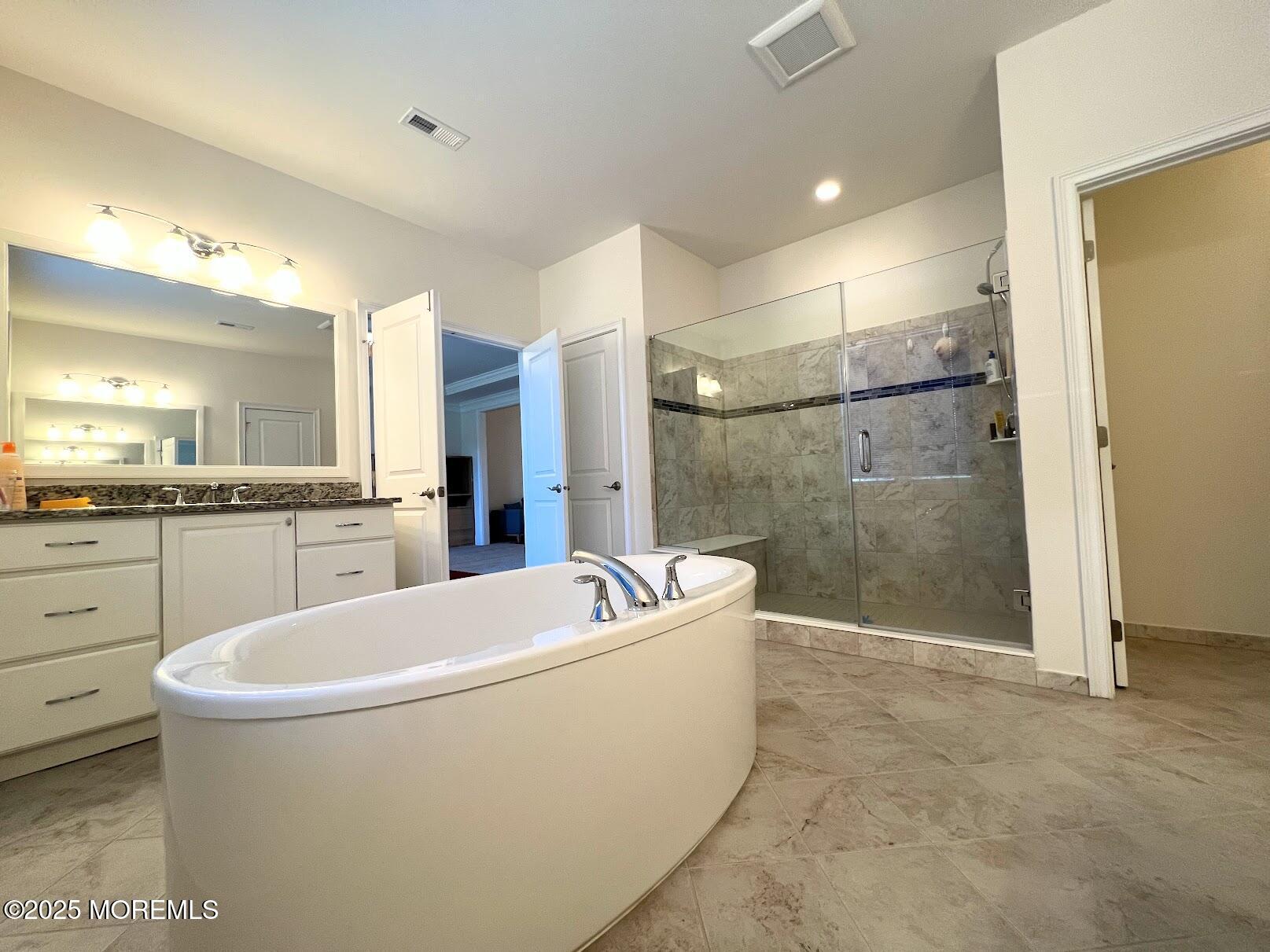 16 Exeter Way Holmdel, NJ 07733 - Photo 31 of 57 a spacious bathroom with a tub a sink shower and mirror