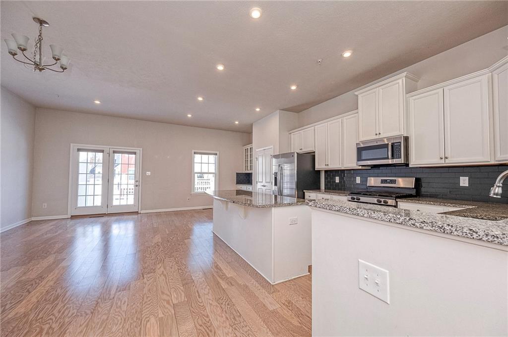 527-529 Tuscarora Road Mars, PA 16046 - Photo 11 of 38 a kitchen with stainless steel appliances granite countertop a stove a sink a refrigerator and white cabinets with wooden floor