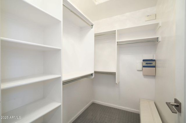 a view of walk in closet with empty racks
