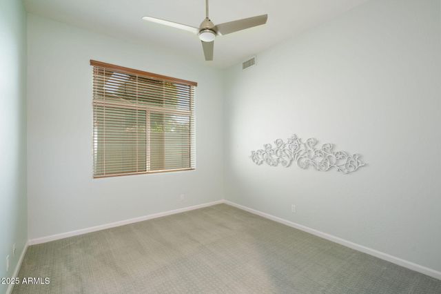 an empty room with a window and ceiling fan