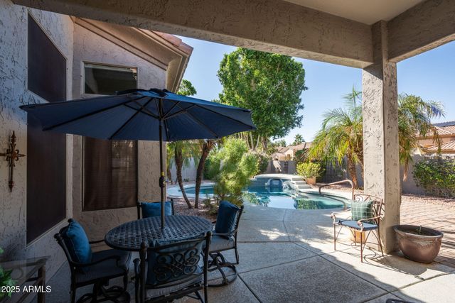 a view of a patio with table and chairs under an umbrella
