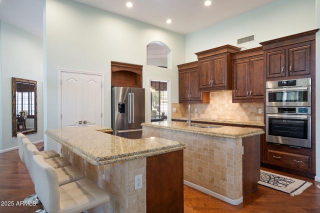 a kitchen with stainless steel appliances granite countertop a sink and a refrigerator
