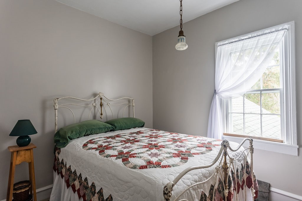 67 Fisk Road Bovina, NY 13753 - Photo 33 of 48 A classic multi-pane window frames quiet outdoor views, filling this bedroom with soft natural light.