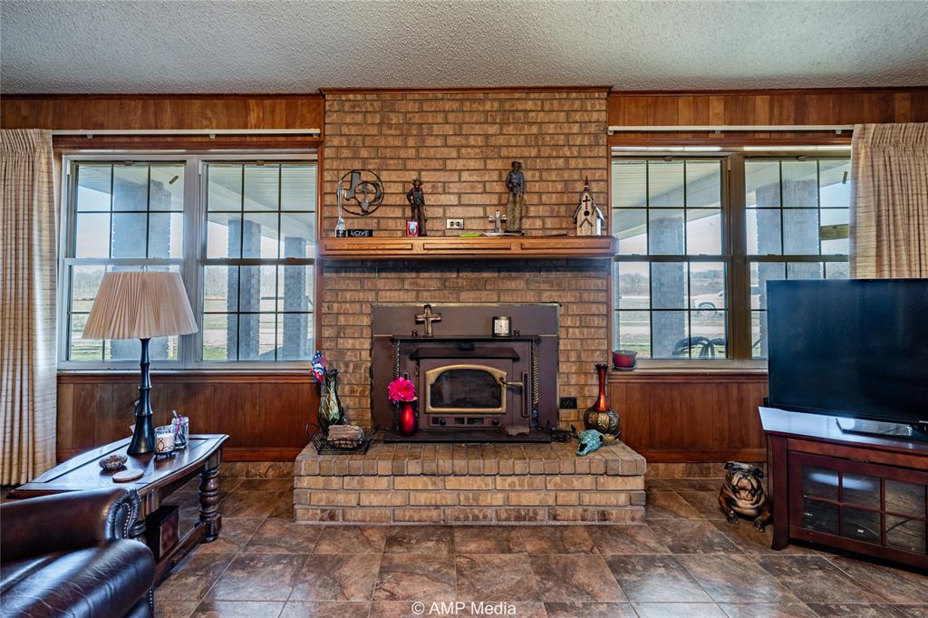 1992 Sand Flat Road Jacksboro, TX 76458 - Photo 24 of 36 Living room featuring a textured ceiling and wood walls