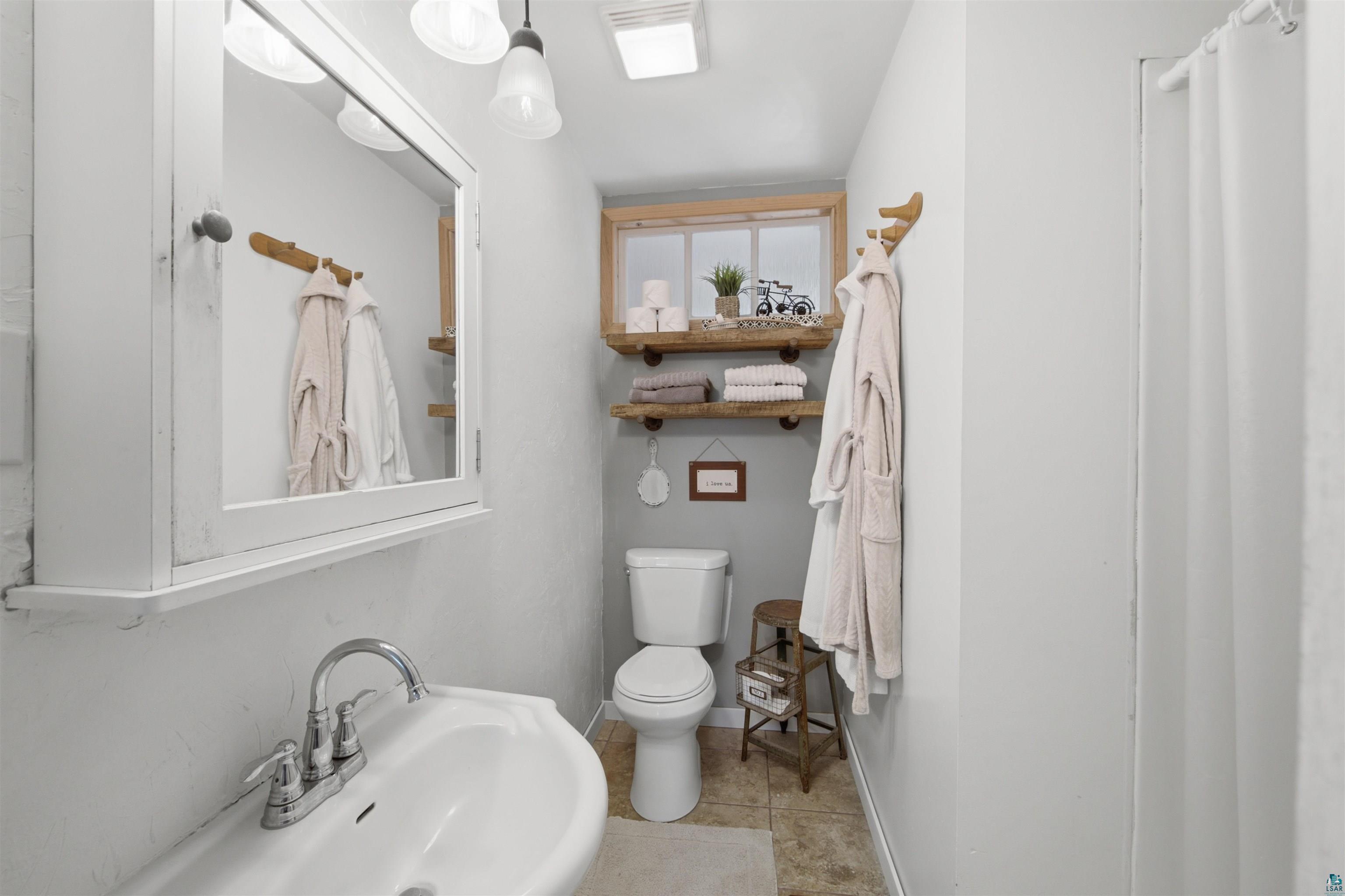 64260 Jolma Road Ashland, WI 54806 - Photo 20 of 35 Bathroom featuring a pedestal sink with chrome faucet, a mirrored medicine cabinet, and overhead lighting