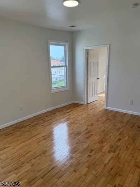 609 South 19th Street, Unit 2 Newark, NJ 07103 - Photo 5 of 8 a view of an empty room with wooden floor and a window
