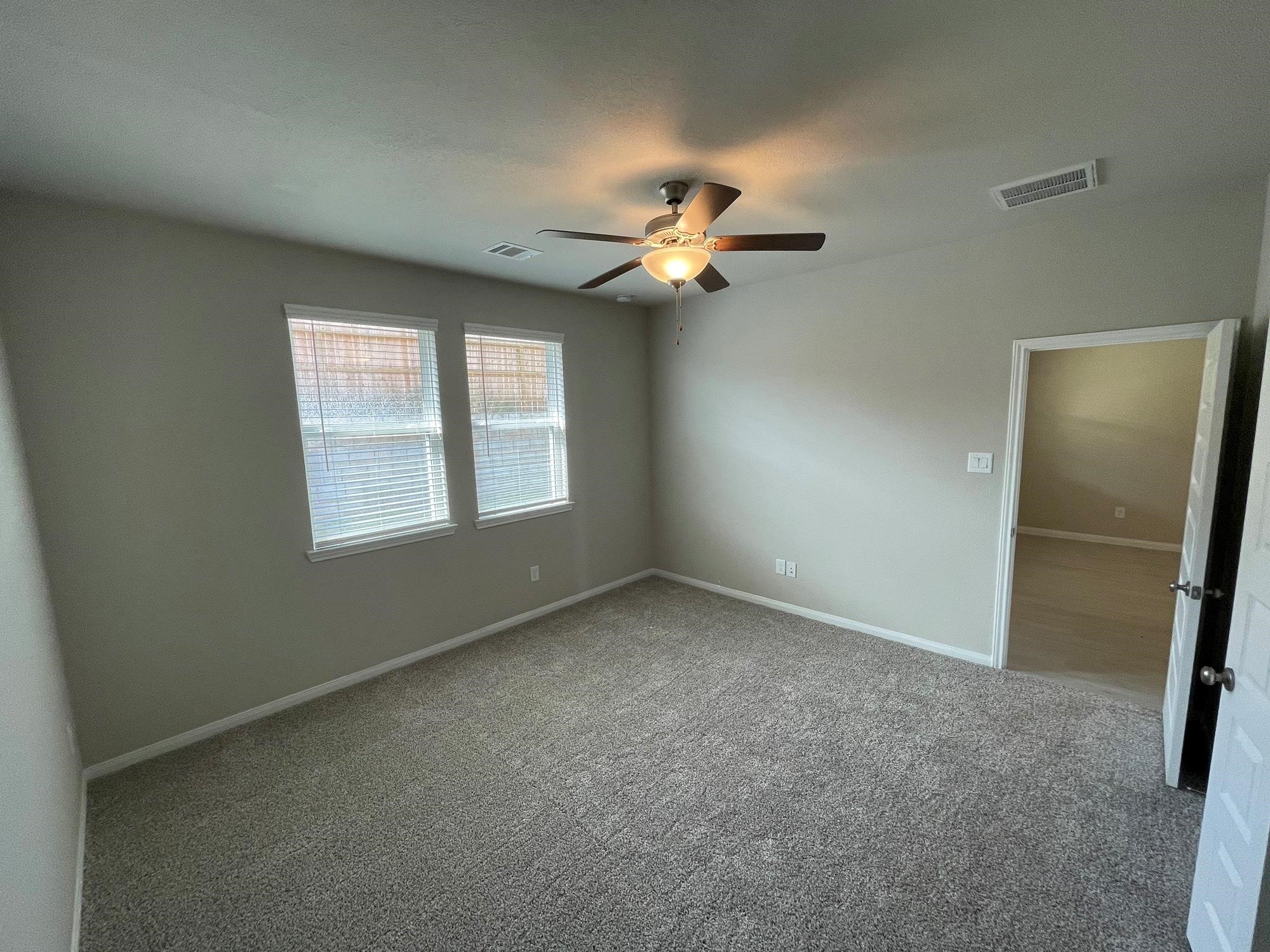 2035 Myrtle Oak Street Conroe, TX 77304 - Photo 13 of 20 an empty room with windows and fan