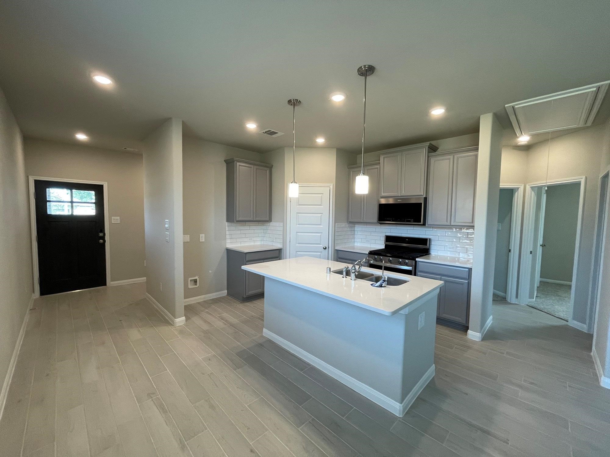 2035 Myrtle Oak Street Conroe, TX 77304 - Photo 7 of 20 a kitchen with kitchen island stainless steel appliances a stove refrigerator sink and microwave