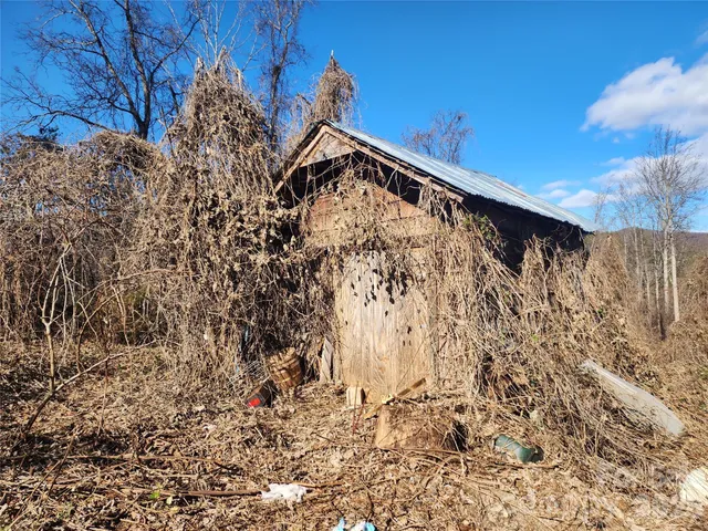 a view of a yard with wooden fence and trees