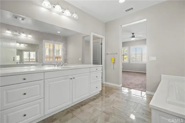 a spacious bathroom with a granite countertop sink mirror and cabinets