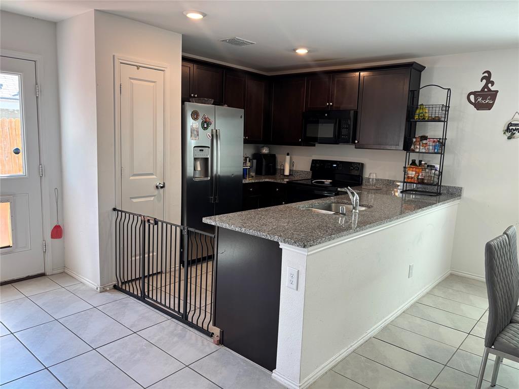 3386 Peyton Lila Road Dallas, TX 75212 - Photo 2 of 13 a kitchen with a sink a refrigerator and a stove top oven