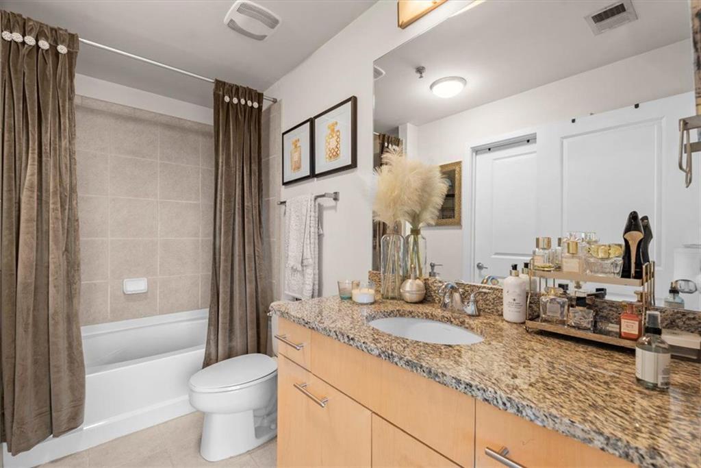3324 Peachtree Road Northeast, Unit 902 Atlanta, GA 30326 - Photo 15 of 29 a bathroom with a granite countertop sink toilet and shower