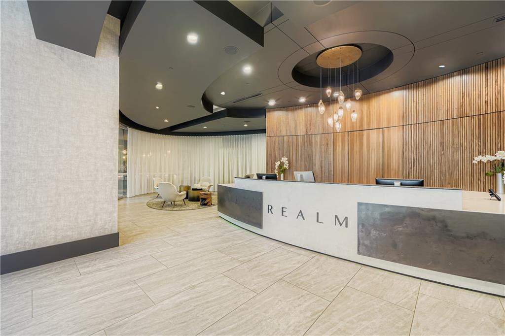 3324 Peachtree Road Northeast, Unit 902 Atlanta, GA 30326 - Photo 20 of 29 a view of a kitchen with kitchen island a sink wooden floor and a counter top space