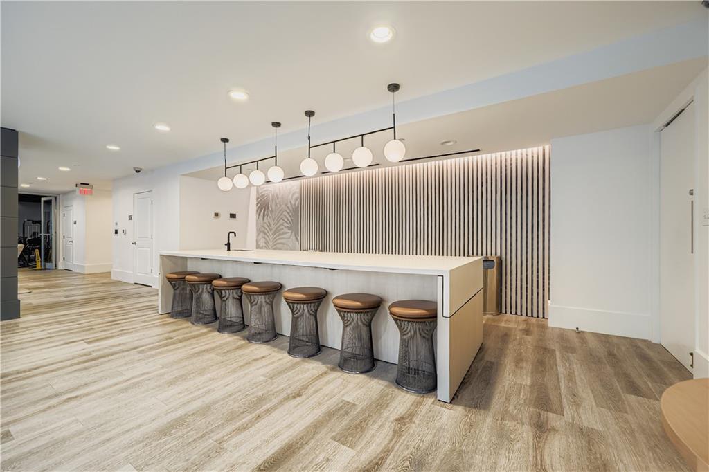 3324 Peachtree Road Northeast, Unit 902 Atlanta, GA 30326 - Photo 21 of 29 a view of a kitchen with kitchen island a sink wooden floor and chairs