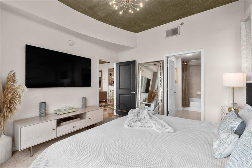 3324 Peachtree Road Northeast, Unit 902 Atlanta, GA 30326 - Photo 6 of 29 a bedroom with a bed and a flat screen tv