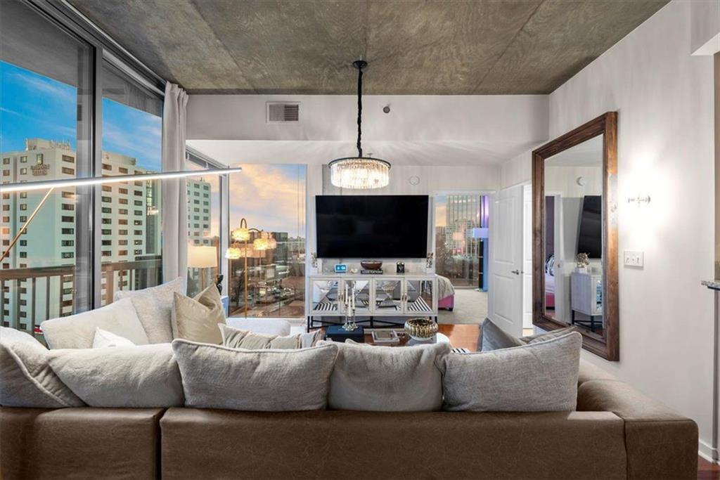 3324 Peachtree Road Northeast, Unit 902 Atlanta, GA 30326 - Photo 8 of 29 a living room with furniture a flat screen tv and a large window