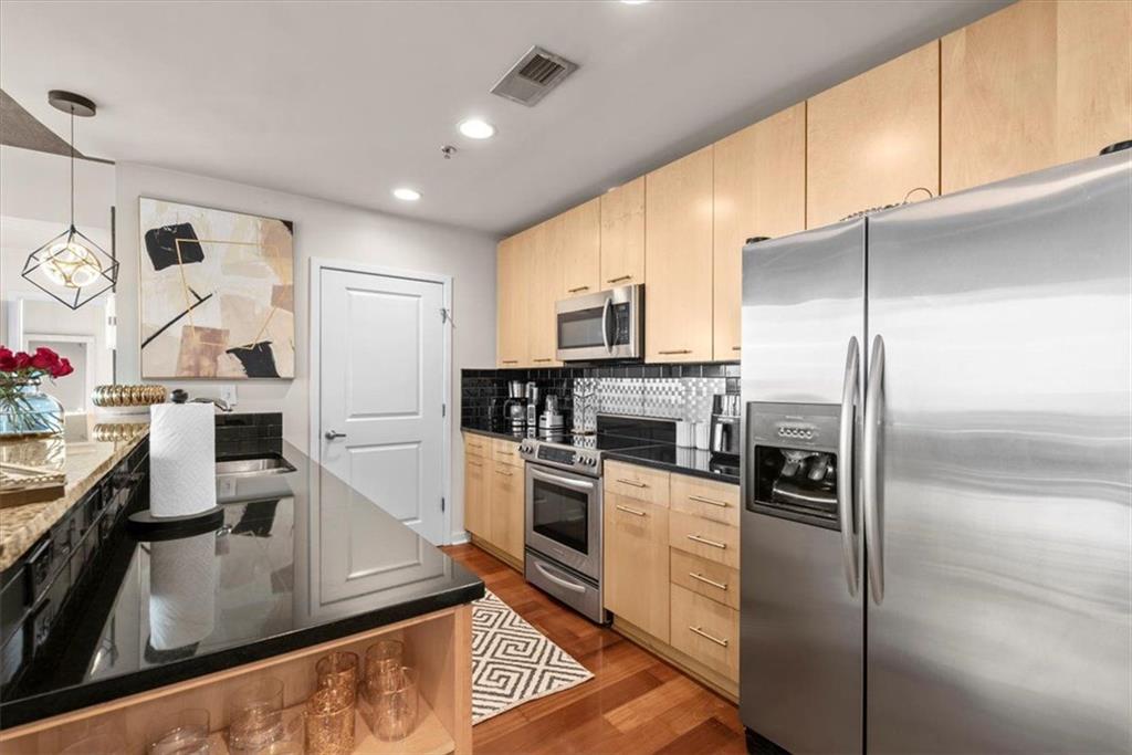3324 Peachtree Road Northeast, Unit 902 Atlanta, GA 30326 - Photo 9 of 29 a kitchen with kitchen island a counter top space cabinets stainless steel appliances and a counter top space