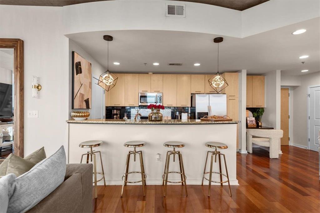 3324 Peachtree Road Northeast, Unit 902 Atlanta, GA 30326 - Photo 10 of 29 a kitchen with stainless steel appliances granite countertop a table chairs refrigerator and microwave