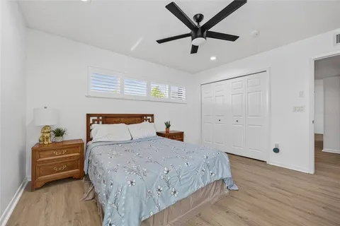 a bedroom with a bed and a ceiling fan
